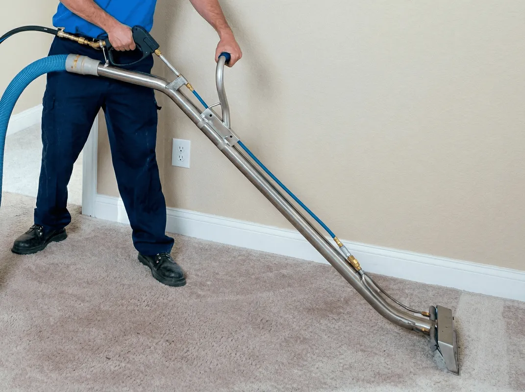Professional operating a liquid removal machine on a carpeted floor in Jackson, MS